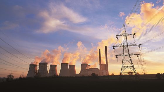 Kraftwerk mit Stromtrasse im Sonnenuntergang