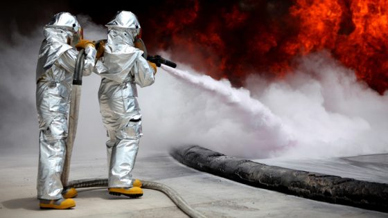 zwei Personen löschen ein Feuer mit einem Löschwasserrückhaltebecken