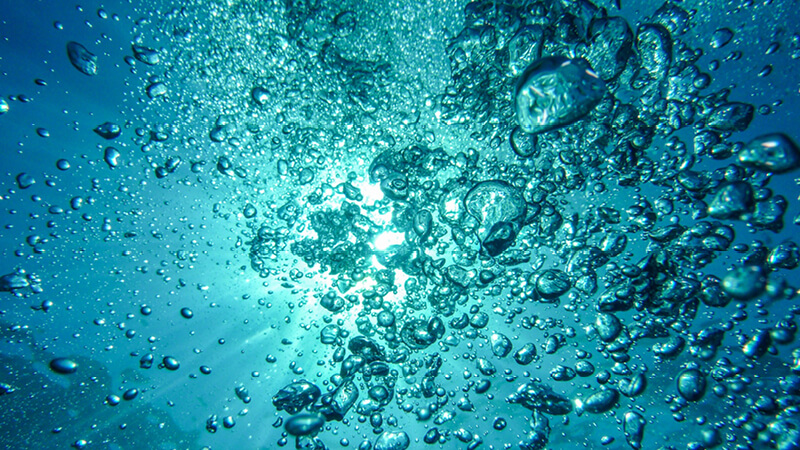 Luftblasen steigen im Wasser auf und werden immer größer